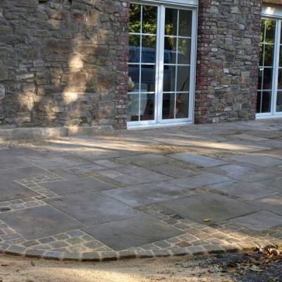 Terrasse aus Natursteinplatten passend zum alten Bauernhaus